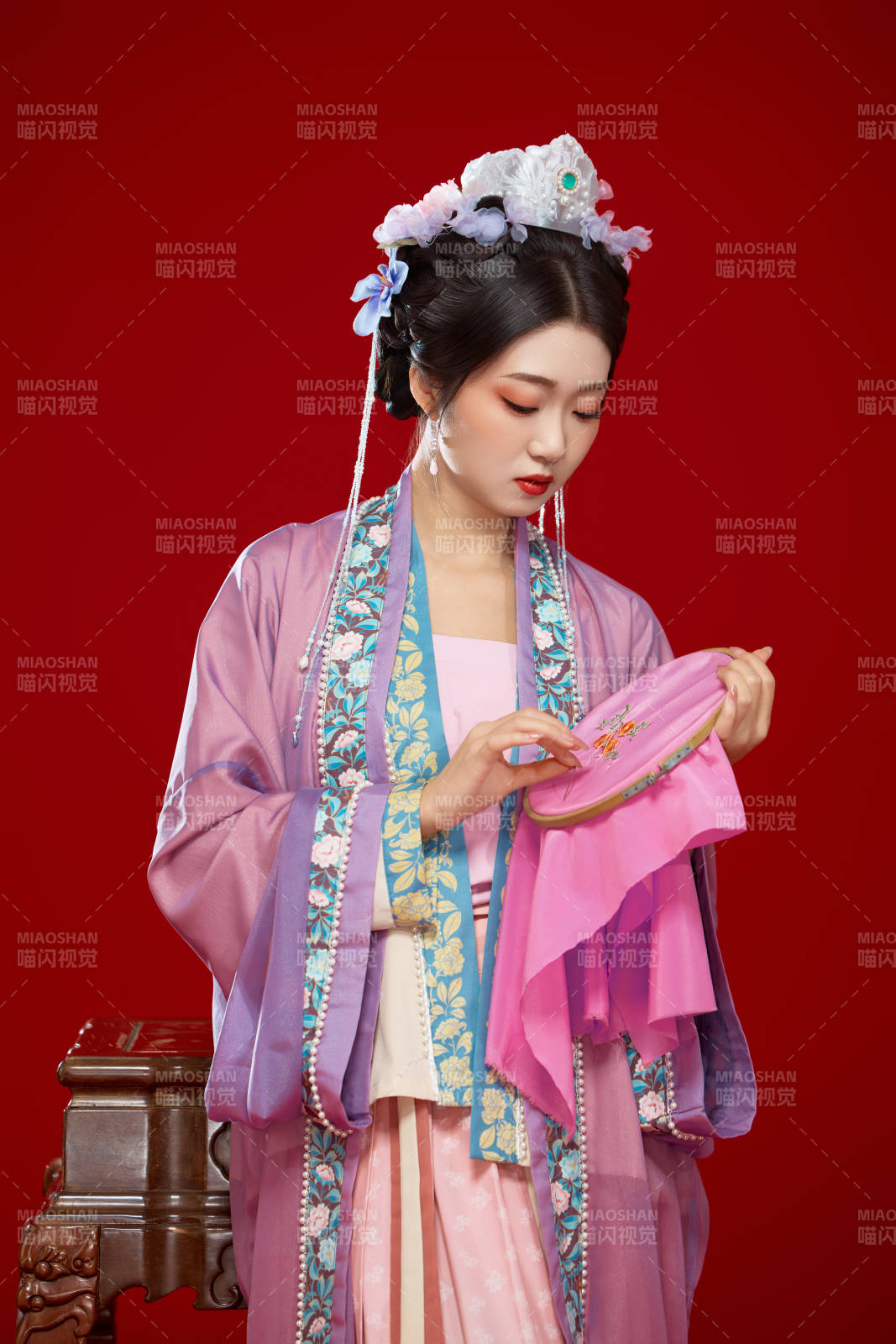 红色背景下身穿中国明朝簪花发饰汉服的美女图片