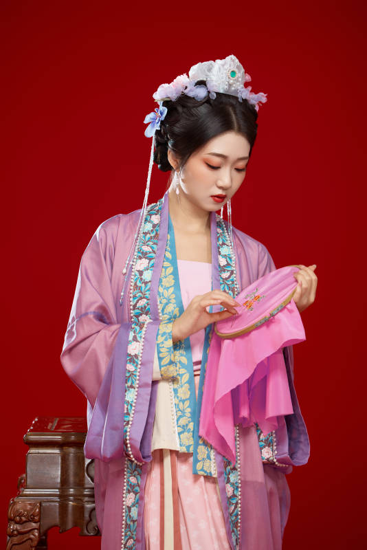 红色背景下身穿中国明朝簪花发饰汉服的美女图片
