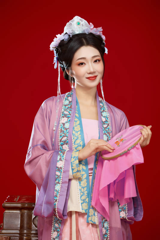 红色背景下身穿中国明朝簪花发饰汉服的美女图片