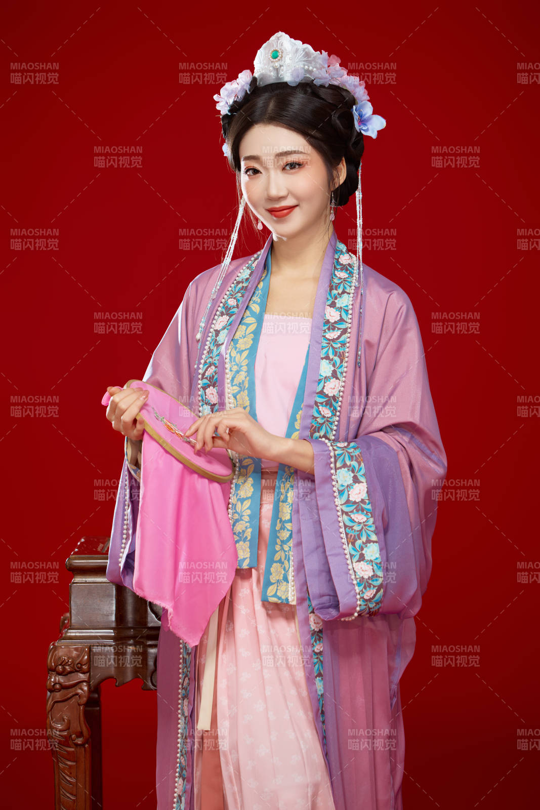 红色背景下身穿中国明朝簪花发饰汉服的美女图片