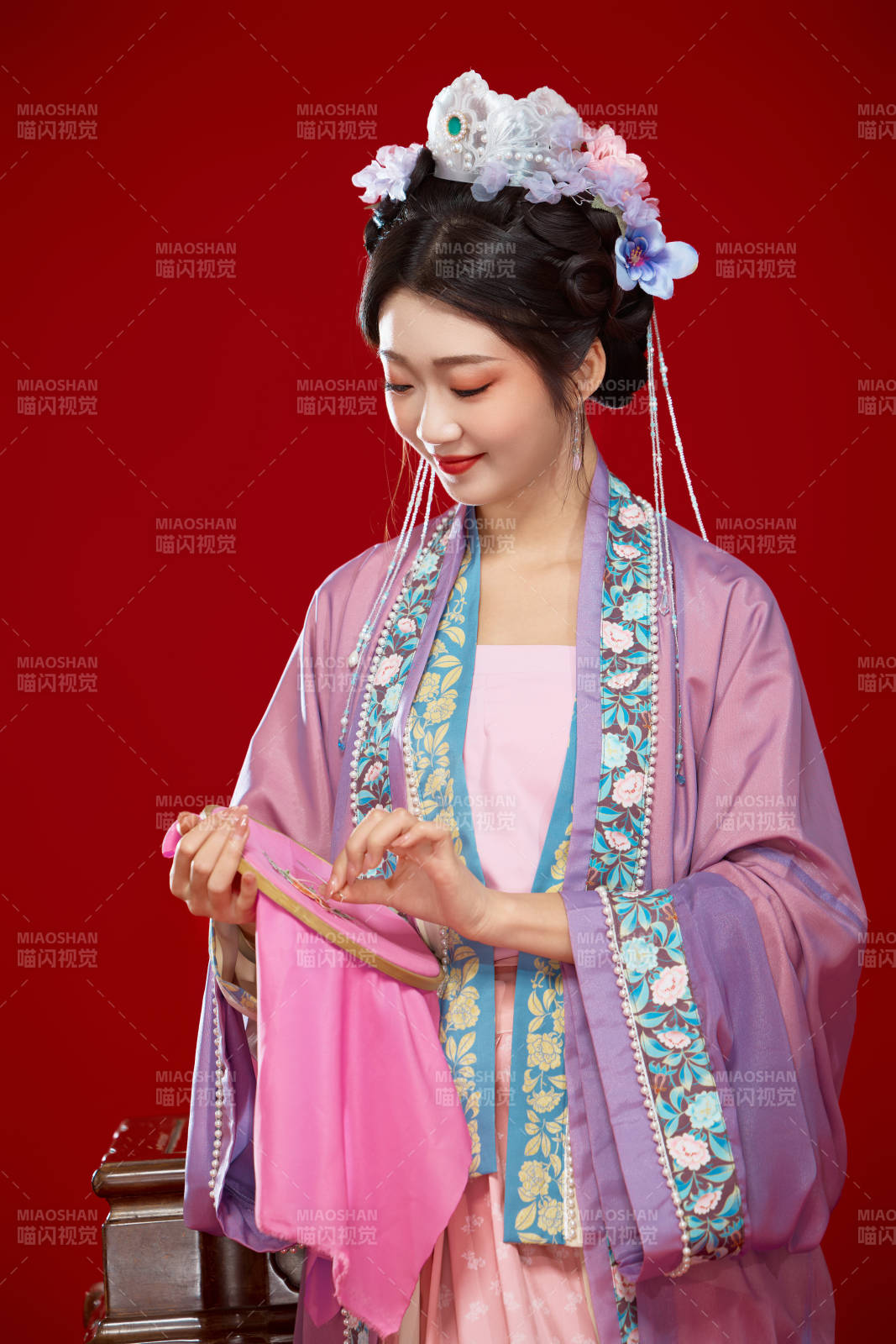 红色背景下身穿中国明朝簪花发饰汉服的美女图片