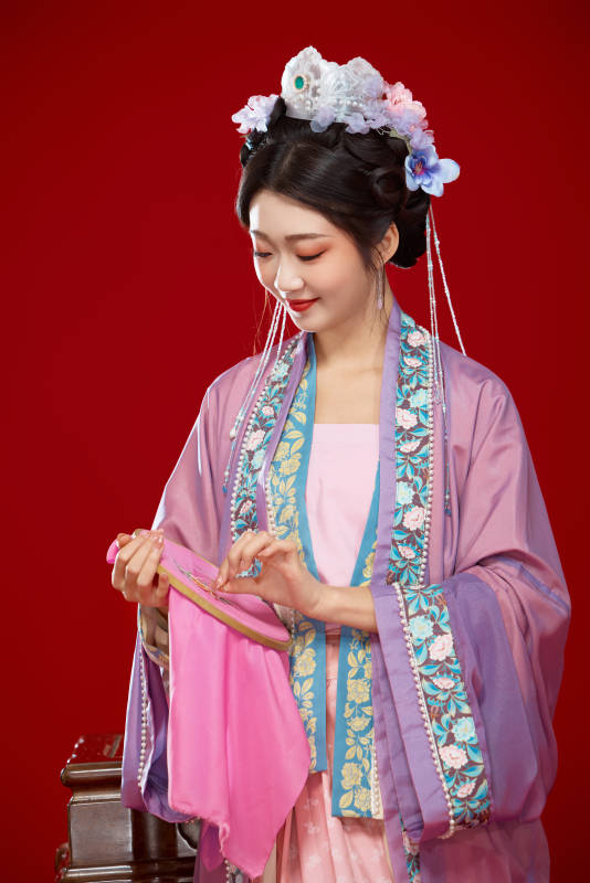 红色背景下身穿中国明朝簪花发饰汉服的美女图片