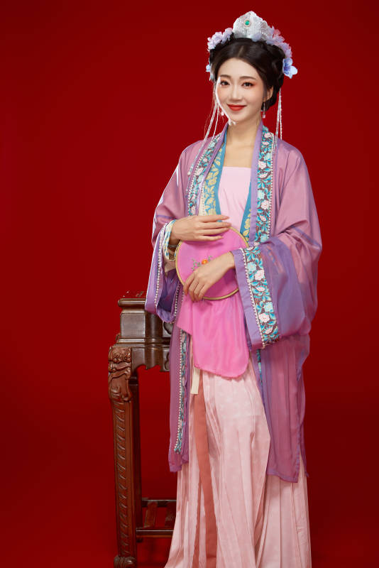 红色背景下身穿中国明朝簪花发饰汉服的美女图片