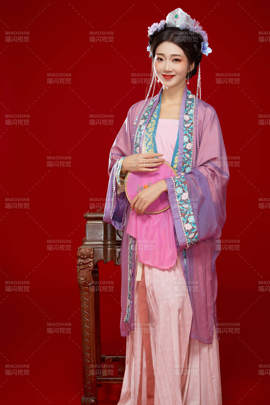 红色背景下身穿中国明朝簪花发饰汉服的美女图片