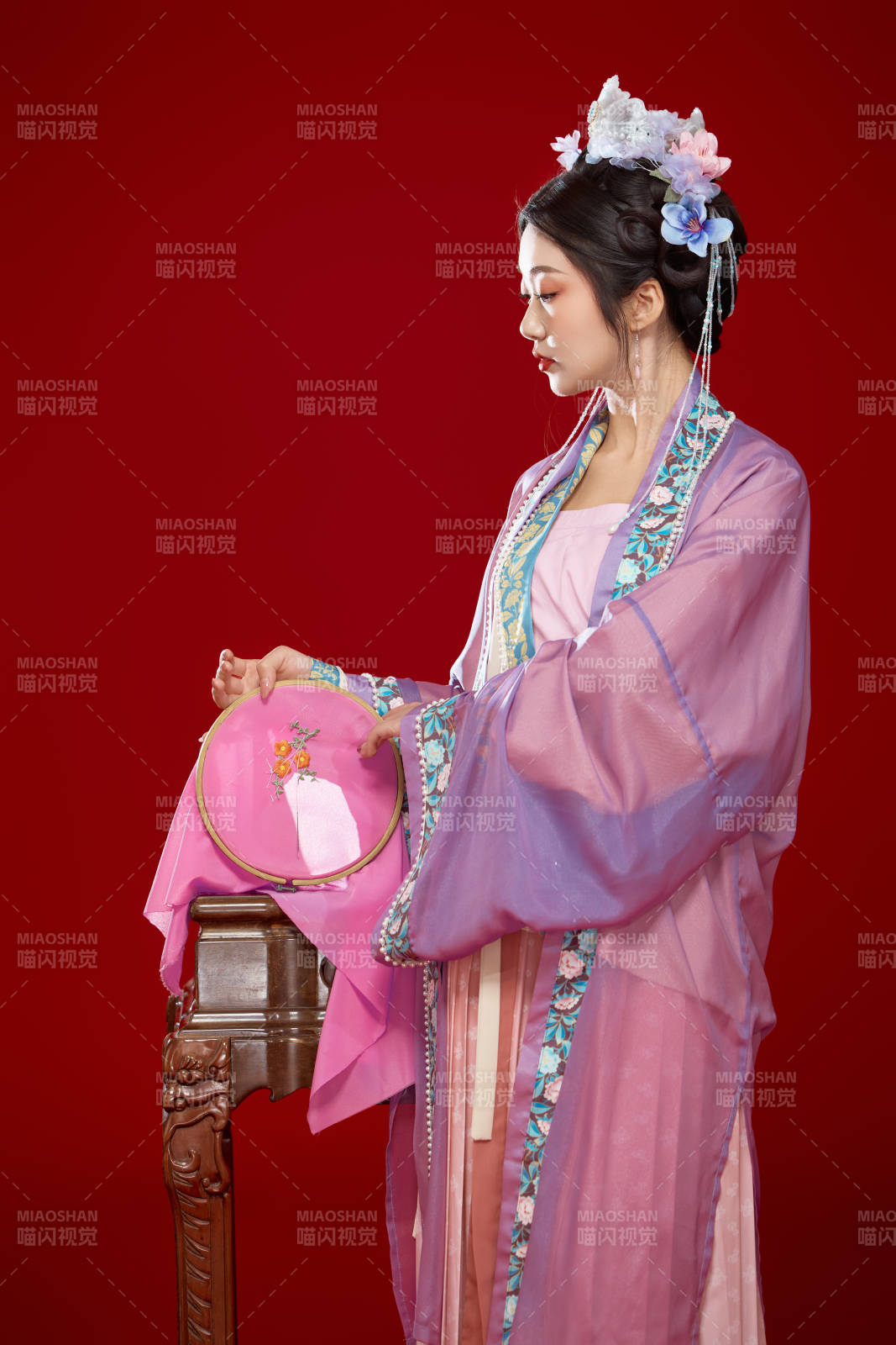 红色背景下身穿中国明朝簪花发饰汉服的美女图片