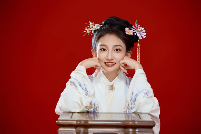 红色背景下穿着中国明朝明制汉服服饰的少女图片