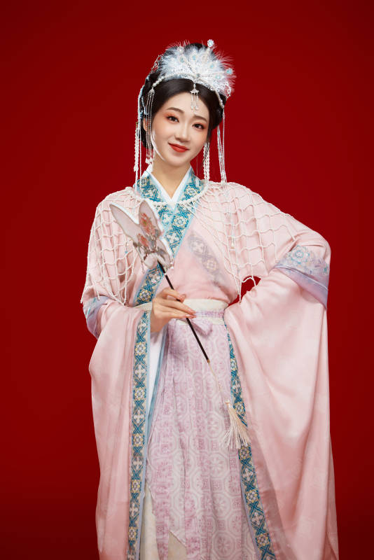 红色背景下身穿中国明朝簪花发饰汉服的美女图片