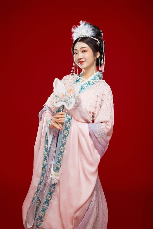 红色背景下身穿中国明朝簪花发饰汉服的美女图片