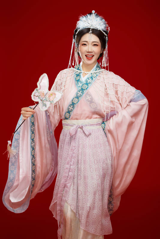 红色背景下身穿中国明朝簪花发饰汉服的美女图片