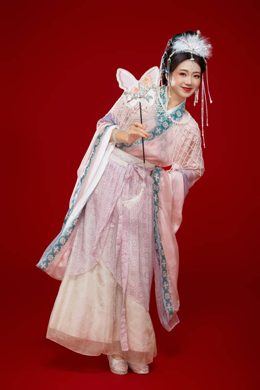 红色背景下身穿中国明朝簪花发饰汉服的美女图片