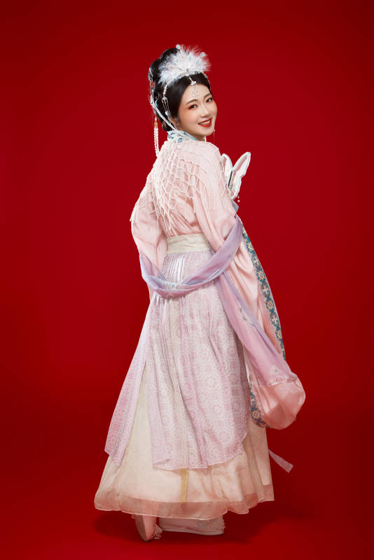 红色背景下身穿中国明朝簪花发饰汉服的美女图片