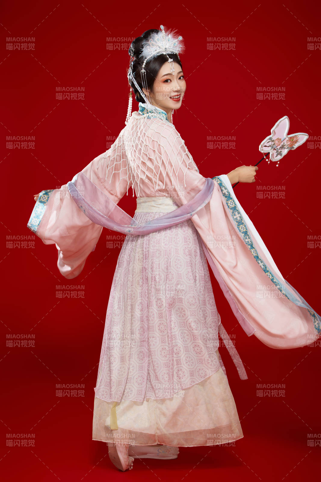 红色背景下身穿中国明朝簪花发饰汉服的美女图片