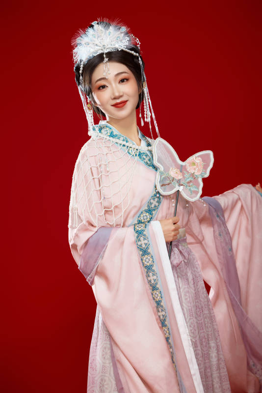 红色背景下身穿中国明朝簪花发饰汉服的美女图片