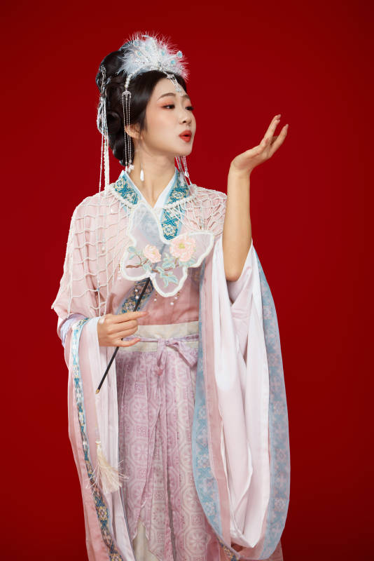 红色背景下身穿中国明朝簪花发饰汉服的美女图片