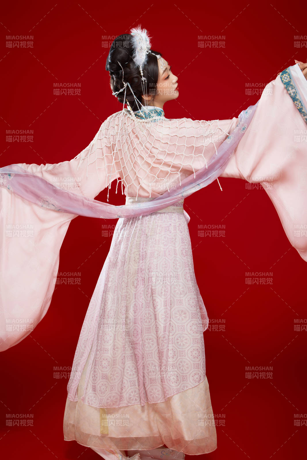 红色背景下身穿中国明朝簪花发饰汉服的美女图片