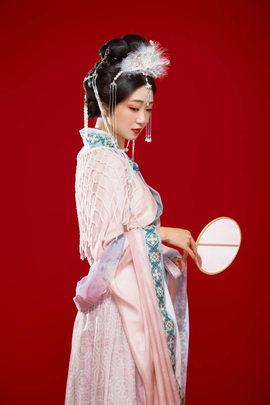 红色背景下身穿中国明朝簪花发饰汉服的美女图片