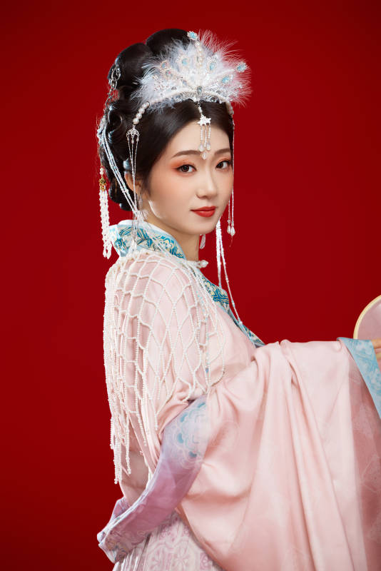 红色背景下身穿中国明朝簪花发饰汉服的美女图片