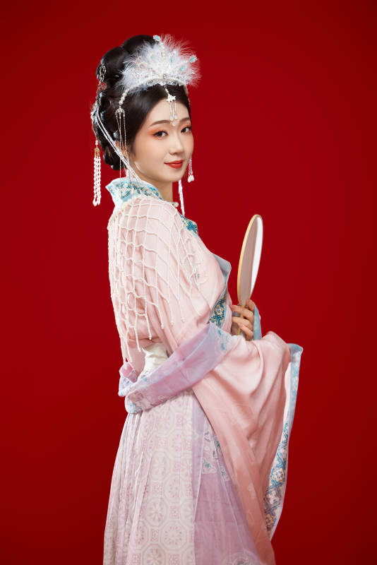 红色背景下身穿中国明朝簪花发饰汉服的美女图片