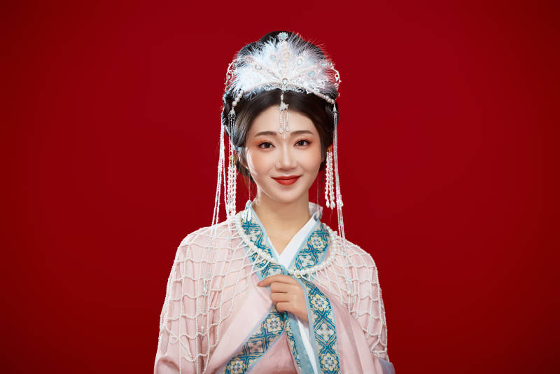 红色背景下身穿中国明朝簪花发饰汉服的美女图片