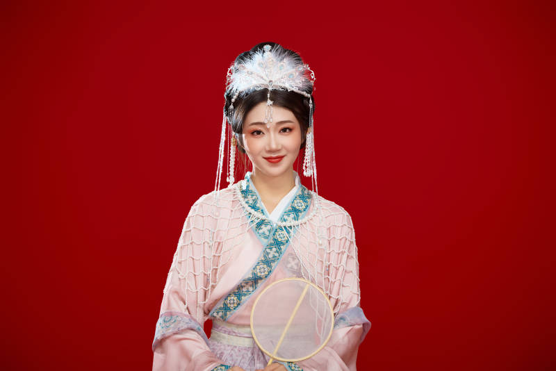 红色背景下身穿中国明朝簪花发饰汉服的美女图片