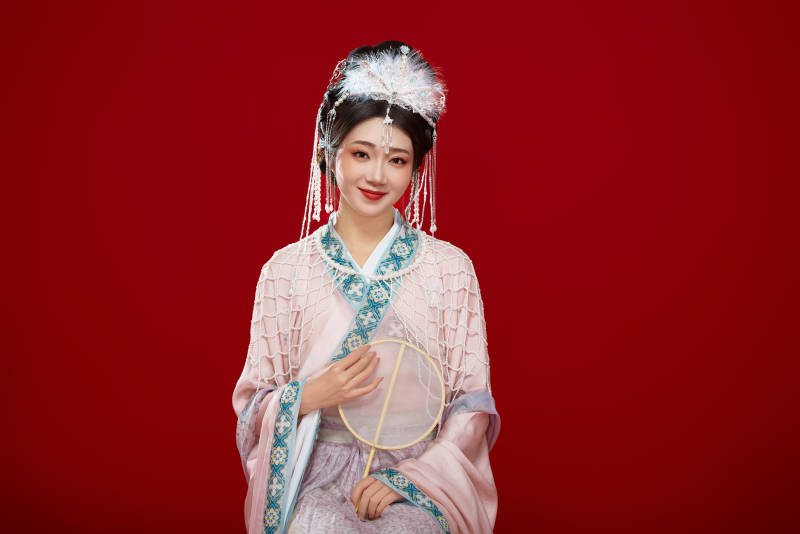 红色背景下身穿中国明朝簪花发饰汉服的美女图片