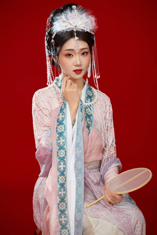 红色背景下身穿中国明朝簪花发饰汉服的美女图片