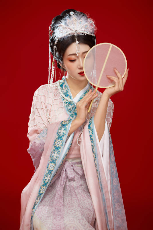 红色背景下身穿中国明朝簪花发饰汉服的美女图片