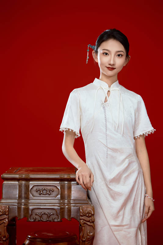红色背景下穿着中式传统旗袍的美丽少女图片