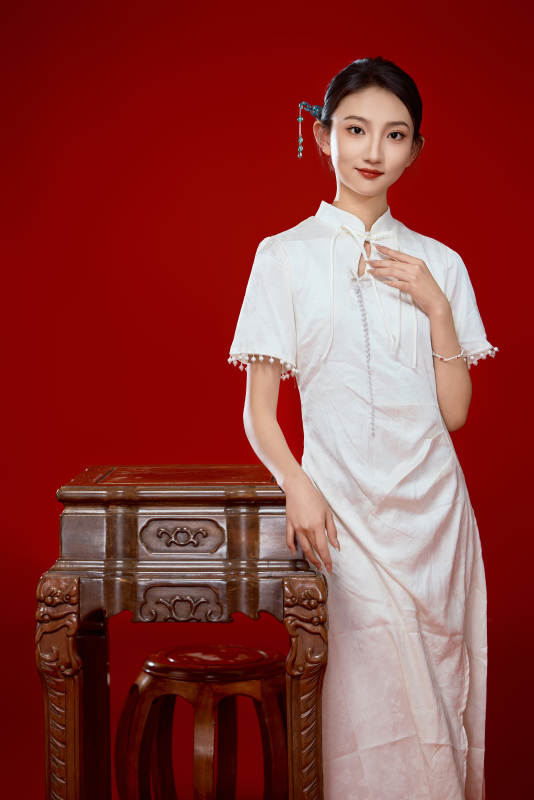 红色背景下穿着中式传统旗袍的美丽少女图片