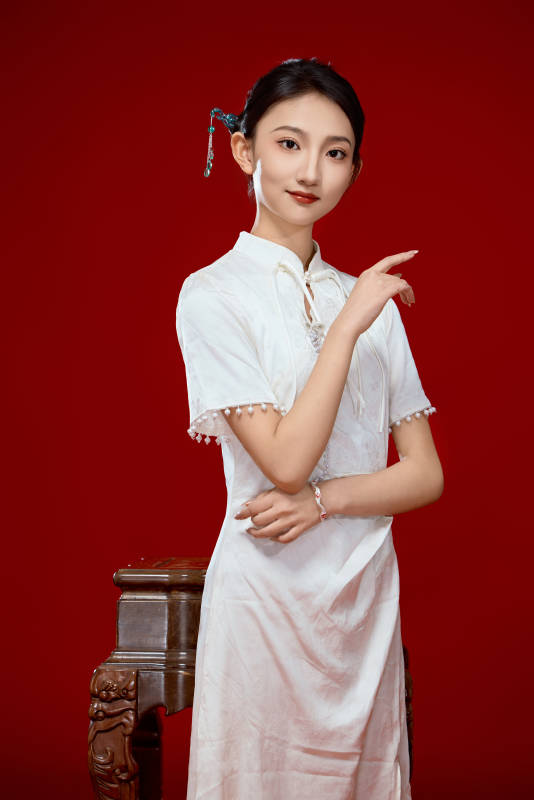 红色背景下穿着中式传统旗袍的美丽少女图片