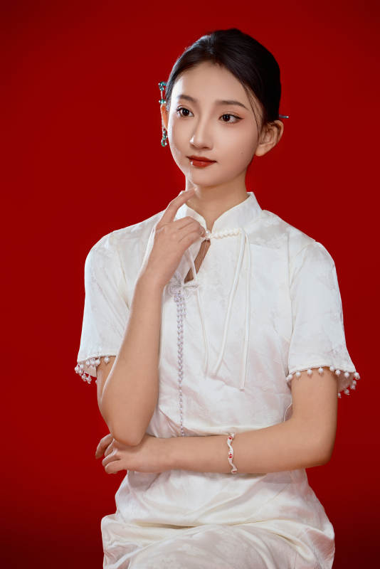 红色背景下穿着中式传统旗袍的美丽少女图片