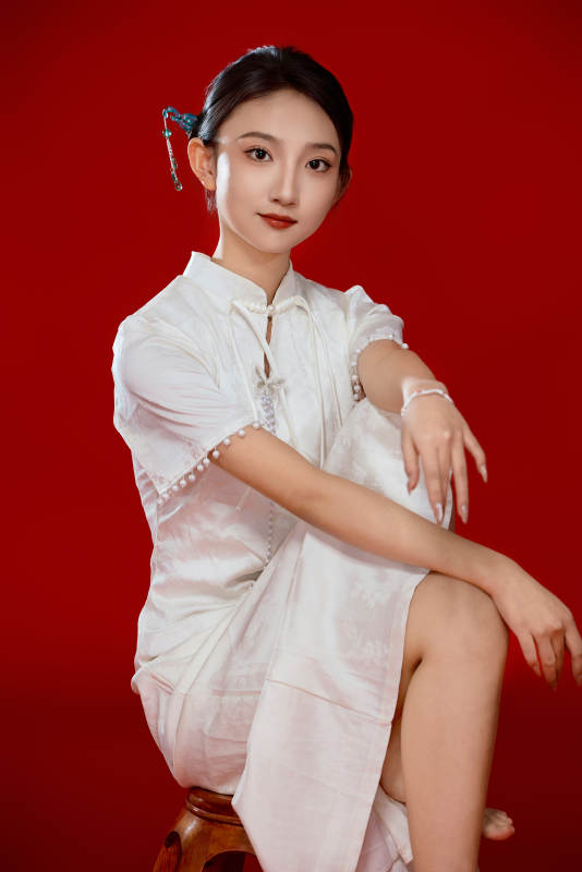 红色背景下穿着中式传统旗袍的美丽少女图片