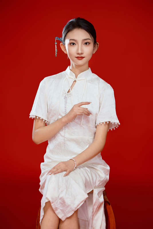 红色背景下穿着中式传统旗袍的美丽少女图片
