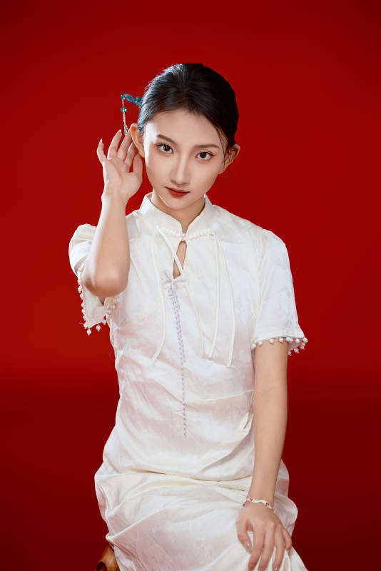 红色背景下穿着中式传统旗袍的美丽少女图片