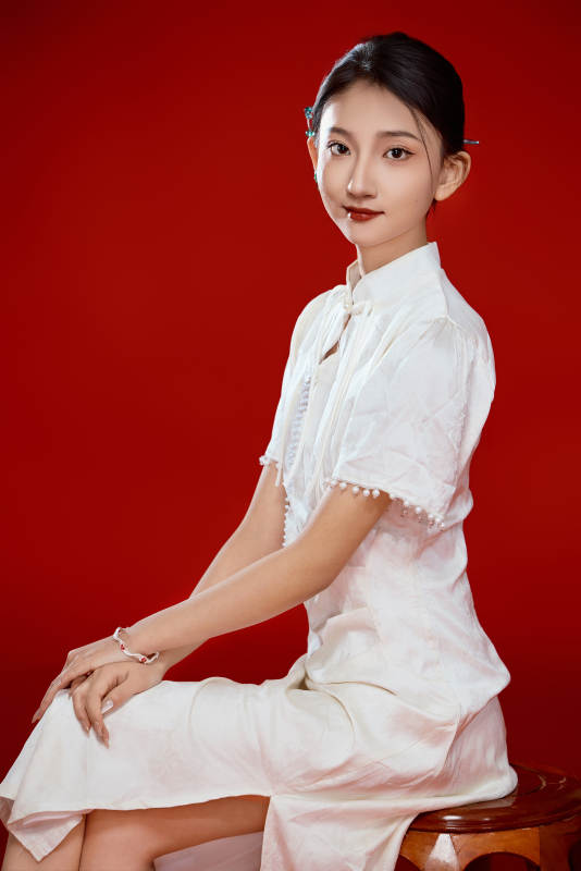 红色背景下穿着中式传统旗袍的美丽少女图片