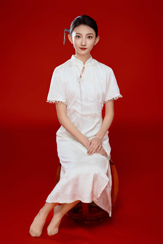 红色背景下穿着中式传统旗袍的美丽少女图片