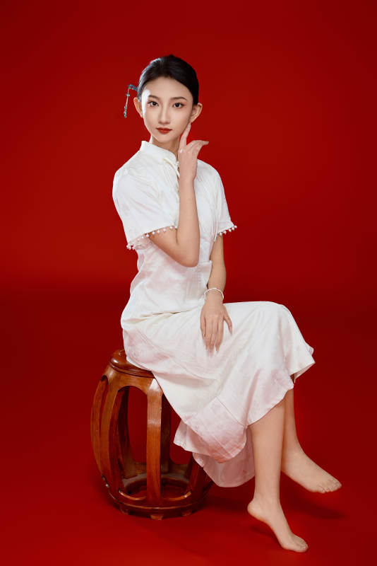 红色背景下穿着中式传统旗袍的美丽少女图片