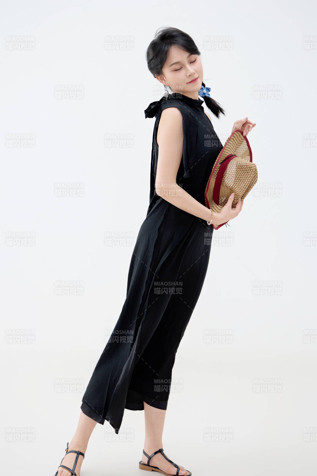 影棚拍摄穿着黑色连体裙的夏日出行美女图片