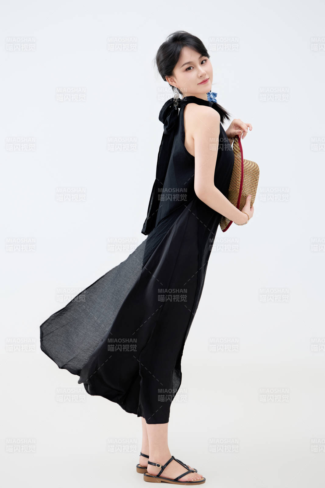影棚拍摄穿着黑色连体裙的夏日出行美女图片