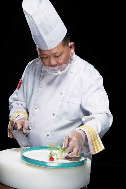 在案板上精心切配美味佳肴的厨师图片