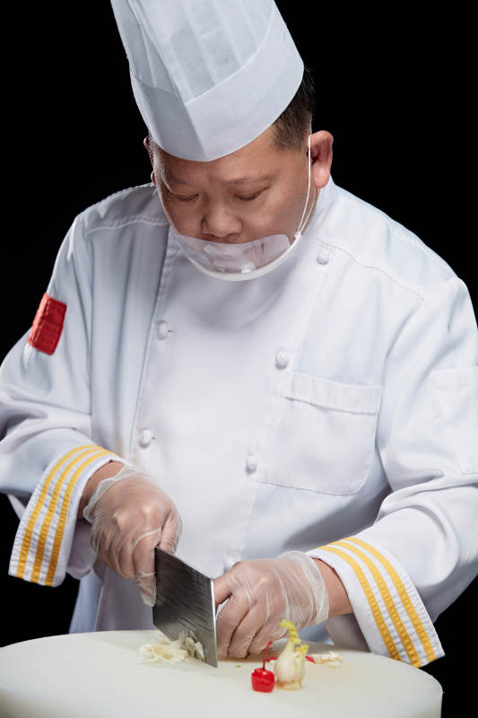 在案板上精心切配美味佳肴的厨师图片