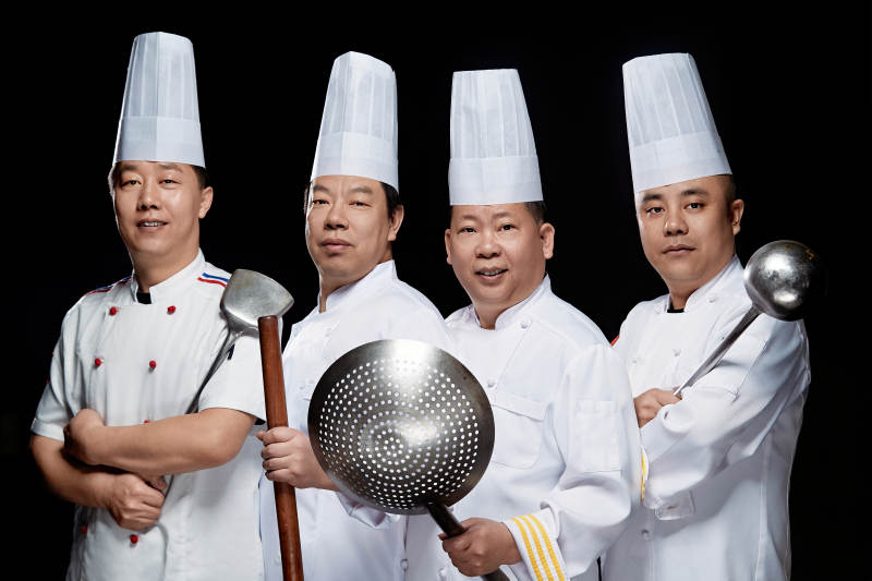 黑色背景下的酒店高级厨师团队形象图片