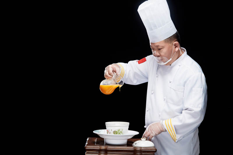 精心制作菜品的高级粤菜厨师图片