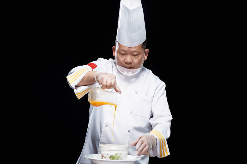 精心制作菜品的高级粤菜厨师图片