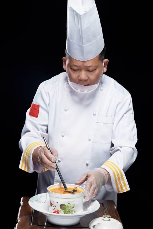 精心制作菜品的高级粤菜厨师图片