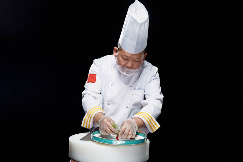 在案板上精心切配美味佳肴的厨师图片