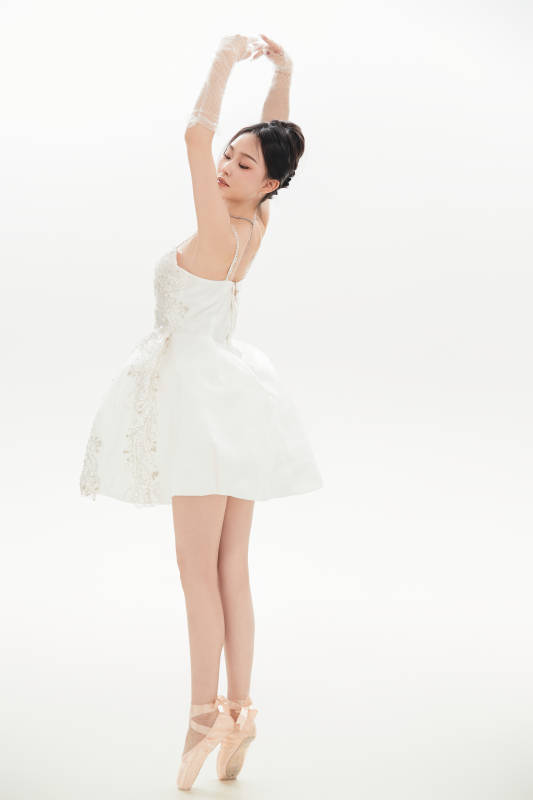 白色背景下跳芭蕾舞的亚洲少女图片