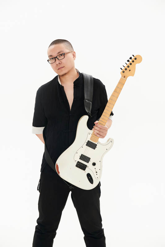 手持电吉他的亚洲男性摇滚乐手图片