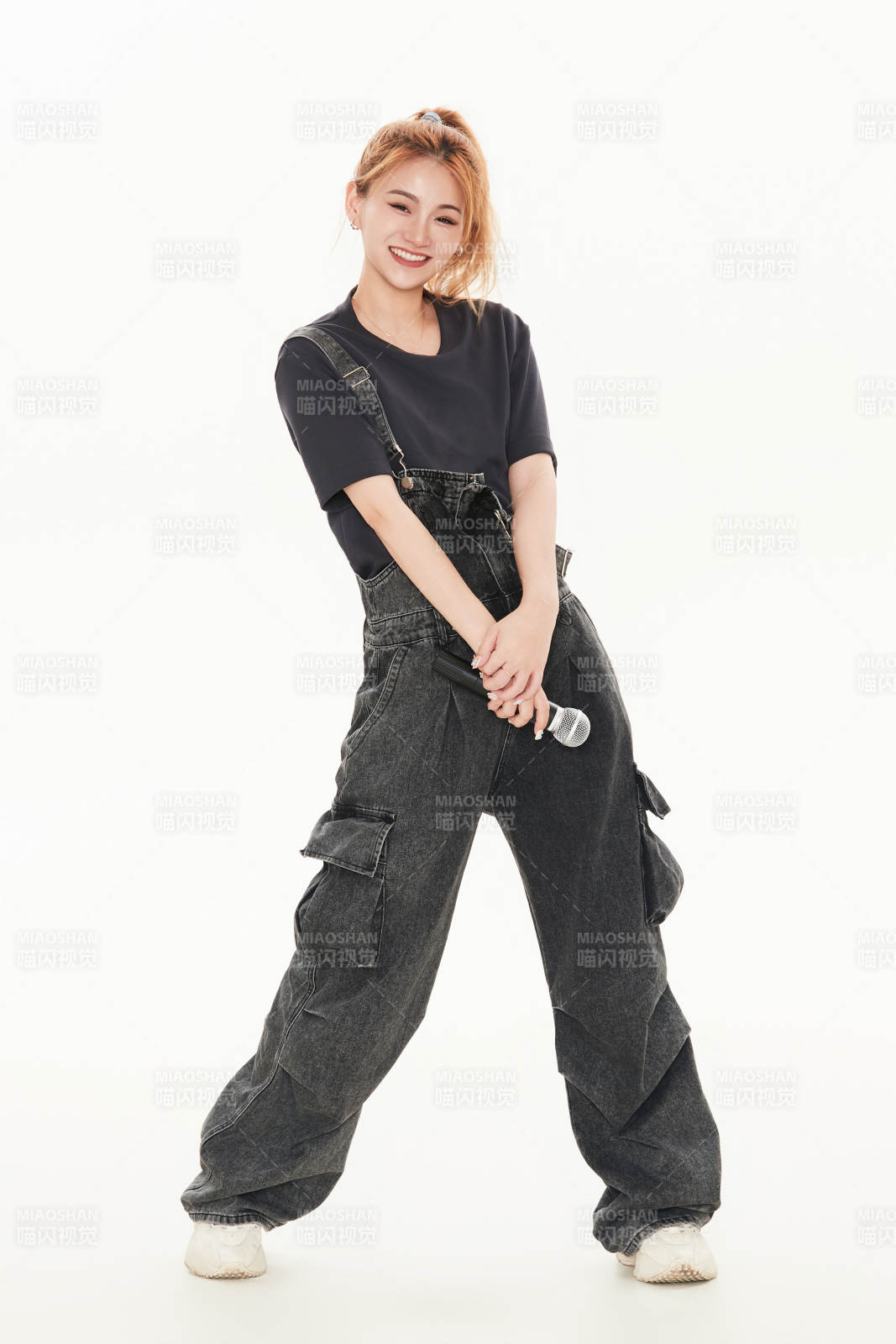 白色背景下手持麦克风的女性歌手图片