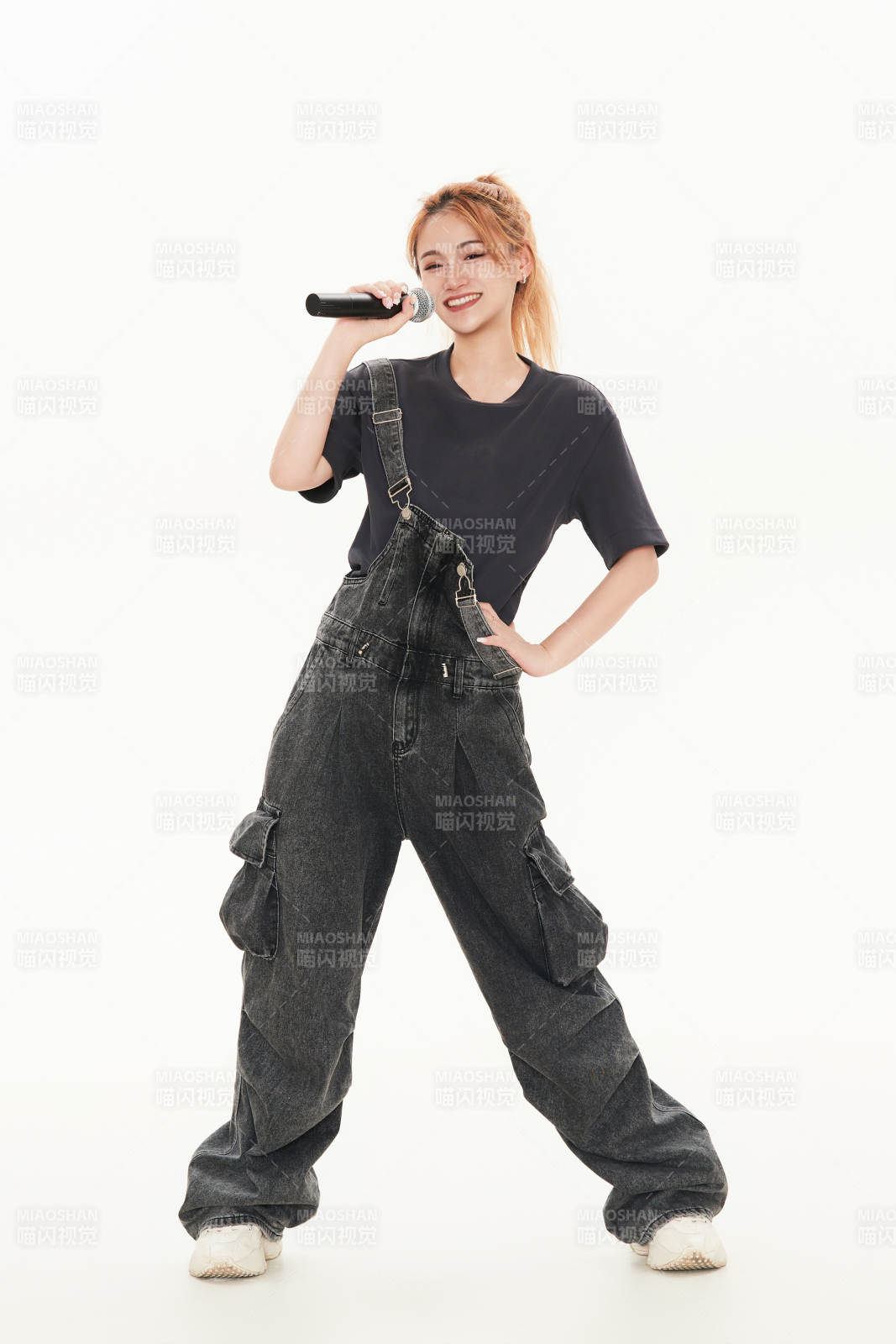 白色背景下手持麦克风的女性歌手图片